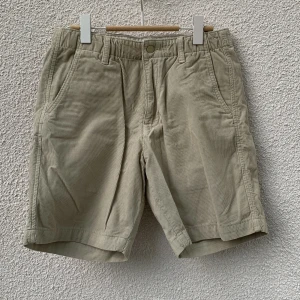 Beiga manchester shorts från Levi's - Säljer ett par beiga shorts från Levi's i mjuk manchester. De har normal passform, bälteshällor, knapp och dragkedja framtill samt fickor både fram och bak. Storlek S.