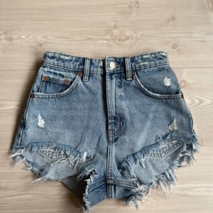 Blå slitna jeansshorts från Zara - Säljer ett par blå jeansshorts från Zara med hög midja. Använda ett fåtal gånger. 