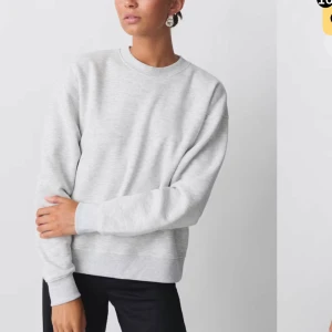 Ljusgrå basic sweatshirt - En stilren ljusgrå sweatshirt med rund halsringning och ribbade muddar. Tröjan har en loose passform och är tillverkad i mjuk bomullsblandning. Perfekt för en chill och avslappnad look. Den är använd men fortfarande fint skick!❤️