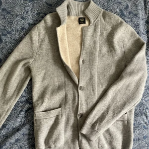 Cardigan kashmir  - Fet cardigan från paul rosen. Sparsamt använd. Den är gjord i ull och kasmir och är i storlek M men sitter lite mer som L. Den är kanske lite lite sliten vid fickorna, men inget man tänker på. 