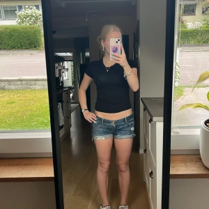 Blå jeansshorts från Hollister - Snygga blå jeansshorts från Hollister med slitna detaljer och uppvikta benslut. Klassisk femficksmodell med dubbla knappar i midjan och logga på bakfickan. Perfekta för varma dagar och en avslappnad stil. Storlek 1, motsvarar XS/ W25. Skriv för frågor o bilder och innan köp!❤️