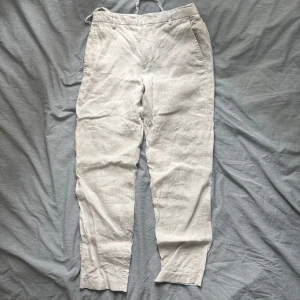 Beiga linnebyxor från Zara, stl S - Snygga beiga linnebyxor från Zara i storlek S. Byxorna har rak passform, sidfickor och resår baktill i midjan för extra komfort. Perfekta för varma dagar och ger en chill och stilren vibe.