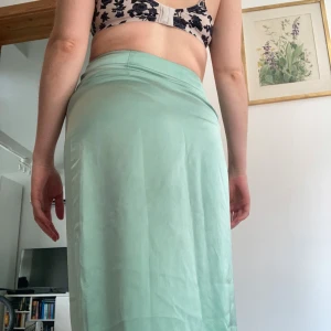Mintgrön långkjol i satin - Säljer en stilren mintgrön långkjol i satin med slät yta och lätt glans. Kjolen har en rak passform och hög midja som ger en clean och modern look. Perfekt för dig som gillar minimalistisk stil och vill ha något som sticker ut med sin fräscha färg. Från märket ONLY i storlek S 🩵Köparen står för frakt 