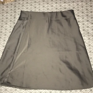  satin kortkjol från BikBok XS - Supersnygg kortkjol från BikBok i satinliknande material. Kjolen har en enkel och stilren design med lätt A-linjeformad passform. Perfekt att matcha med en crop top eller stickad tröja för en trendig look.