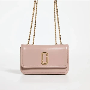 Rosa axelväska från Marc Jacobs -  Säljer en snygg rosa axelväska från Marc Jacobs med guldfärgad kedja och logga framtill. Väskan är liten och smidig, perfekt för det viktigaste. Stilren design med mjukt skinn och elegant känsla. Nypris cirka 4000