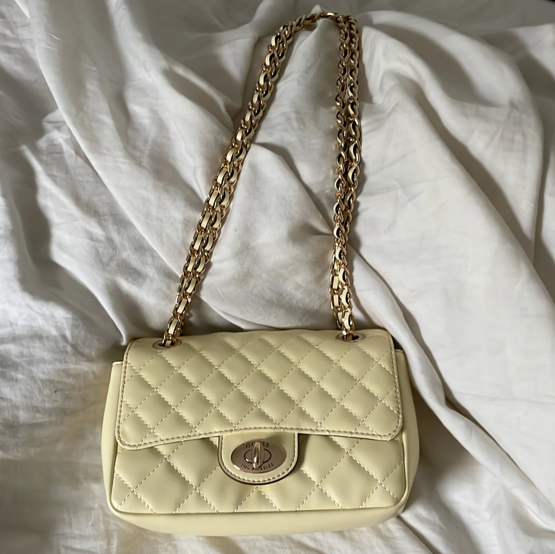 Quiltad axelväska från Guess i ljusgul