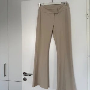 Beiga bootcut byxor från Gina Tricot - Snygga beiga bootcut-byxor från Gina Tricot i stretchigt material, väldigt långa och snygga i benen! De har låg midja och sitter lite mer loose på höften💕 Endast provade men saknar prislapp!