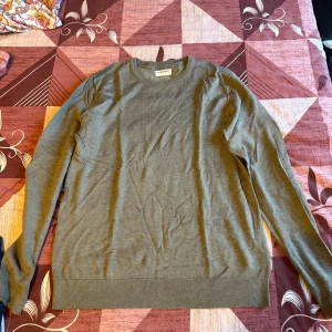 Olivgrön tröja från Lindbergh White - Snygg olivgrön tröja från Lindbergh White i storlek M. Tröjan har rund halsringning, ribbade muddar och är tillverkad i ett mjukt material som känns skönt mot huden. Perfekt för lager-på-lager och enkel att matcha med jeans eller chinos.