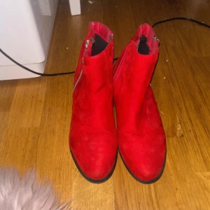 Röda boots med dragkedja - Snygga röda boots i mocka med dragkedja på sidan. Perfekta för att ge en färgklick till din outfit. De har en låg klack och rundad tå, vilket gör dem bekväma att bära hela dagen.