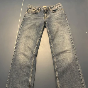 Blå jeansbyxor - Klassiska blå lågmidjade jeans med en straight passform och femficksdesign. Byxorna har en knapp och dragkedja framtill. Perfekta för en avslappnad stil. Köptes från Nelly och säljer då de inte används.  Använt ett fåtal gånger💞hör av dig vid mått eller andra frågor🥰