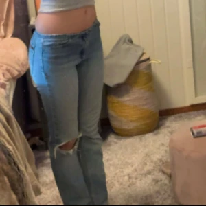 SNYGGA BOOTCUT JEANS!! - Snygga blå jeans med slitningar på knäet. De har en tight passform och är lågmidjade, och utsvängda.☺️💞 Säljer på grund av att det inte används, jag är  165cm lång och midjemåttet äe 37cm!! Innerbenet är 73cm långt!!😚DM om några frågor💕💕💕