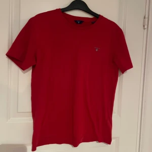 Röd t-shirt från GANT - Säljer en snygg röd t-shirt från GANT med en liten logga på bröstet. Funkar lika bra till tjejer och killar. Storlek 170