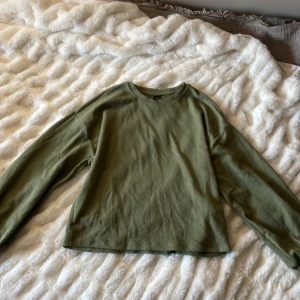 Olivgrön ribbad tröja från Vero Moda - Säljer en olivgrön ribbad tröja från Vero Moda. Tröjan har långa ärmar och en rund halsringning. Perfekt för en avslappnad stil. Passar bra till jeans eller kjol.