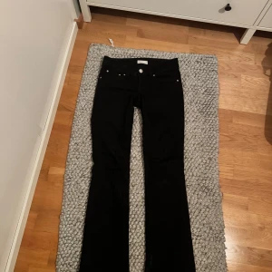 Svarta bootcut jeans - Snygga lågmidjade svarta bootcut jeans med  knappar på fickorna. De är från Gina och knappast använda. Kan tänka mig att gå ner i pris vid snabb affär. 