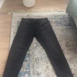 Svarta tapered jeans - Säljer ett par svarta tapered jeans och är i storlek 29/30. Perfekta för en avslappnad men ändå snygg stil. Helt oanvända, men har ingen prislapp. Priset är inte hugget i sten. Kontakta mig angående frågor!🤩