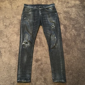 Svarta jeans från Dondup - Snygga svarta skinny fit jeans från Dondup med slitna detaljer. Storleken är 33 men sitter som 34/35. Dessa jeans har en modern look med en smal passform. Perfekta för en trendig stil. 