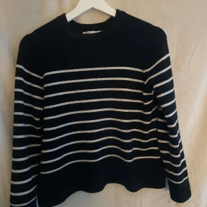 Svart och vit randig tröja från Zara - Säljer en stilren svart tröja med vita ränder från Zara. Tröjan har långa ärmar och en klassisk rund halsringning. Perfekt för en avslappnad och trendig look.