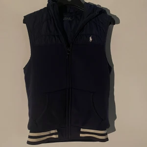 Mörkblå väst från Polo Ralph Lauren - Snygg mörkblå väst från Polo Ralph Lauren, skit skön nu till höst och går riktigt bra med mina jeans jag säljer. Rekomderar starkt och skickas under helgen om du köper! Pris diskuteras vid snabbt köp 