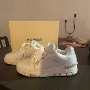 Vita sneakers från Axel Arigato - Snygga vita sneakers från Axel Arigato. Säljer då dem inte riktigt va min stil. Lite samma stil som adidas campus skorna. Använd fåtal gånger så är inprincip helt nya i skicket. 