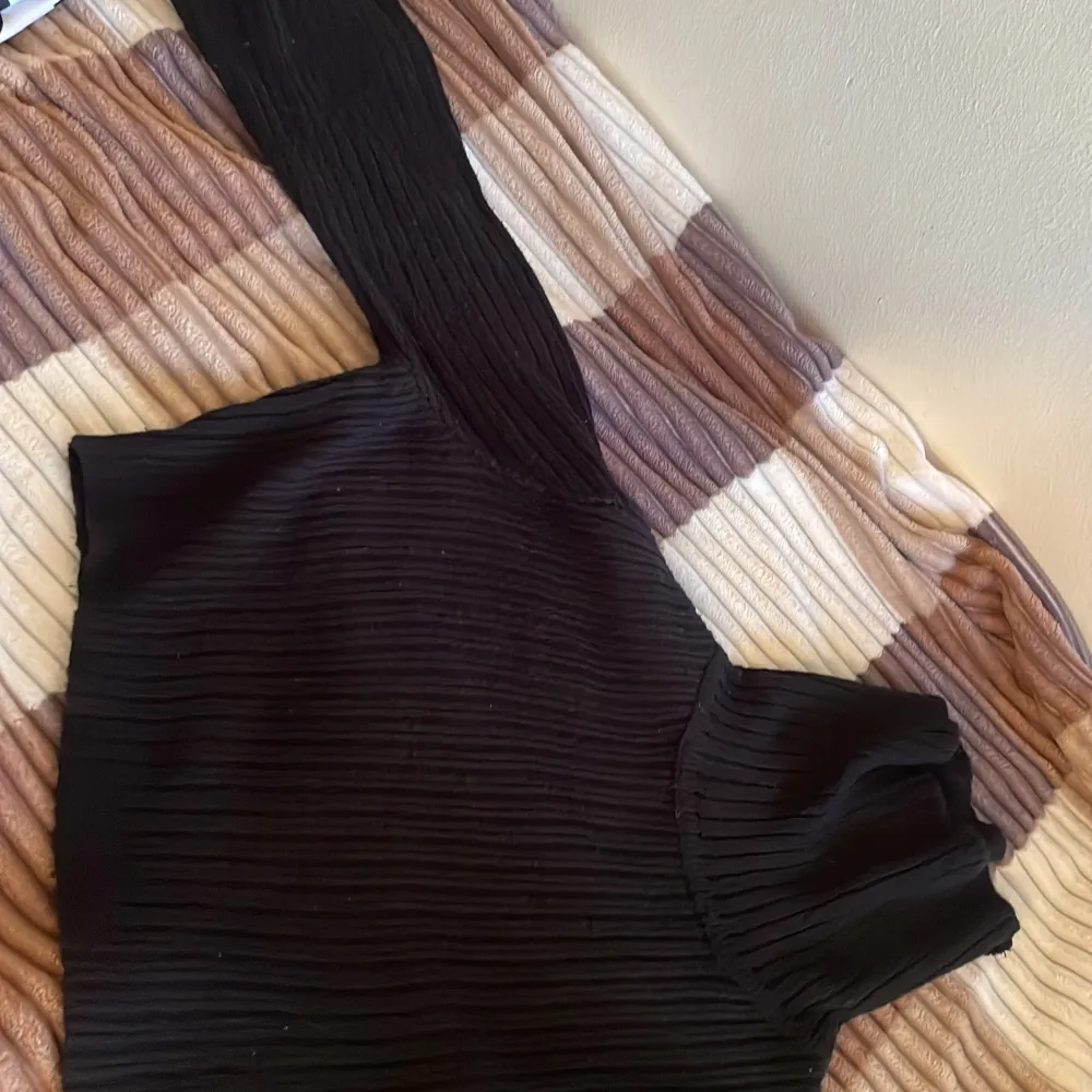 Snygg svart ribbad polotröja med långa ärmar. Perfekt för en stilren look. Tröjan har en hög krage som ger extra värme och stil. . Neuletakit & Villapaidat.