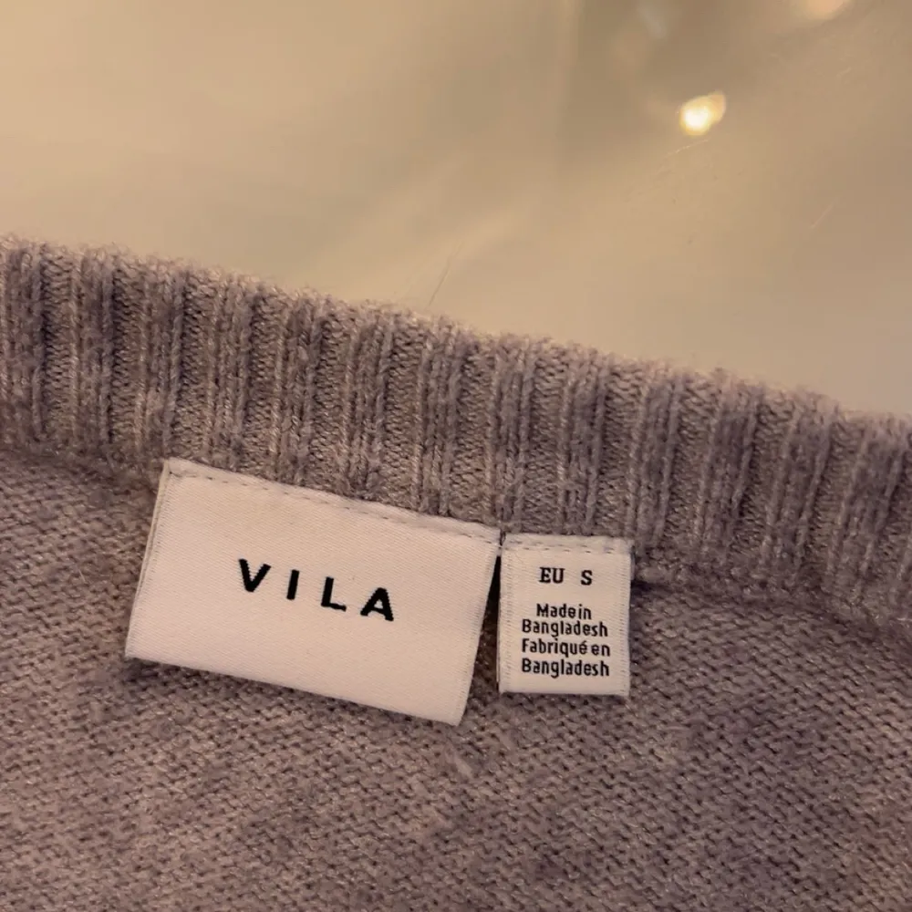 Säljer en stilren grå tröja från VILA. Tröjan är långärmad med ribbade muddar och rund halsringning. Perfekt för en avslappnad look.💞. Neuleet.