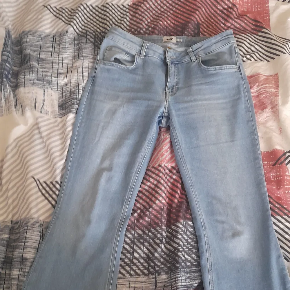 Snygga ljusblå jeans med bootcut-stil. De har en klassisk femficksdesign och en knappgylf. Perfekta för en avslappnad look. De är från lager 157. Har bara använt det 2 gånger eftersom jag har blivit smalare och dem är inte perfekta för mig nån längre . Farkut & Housut.