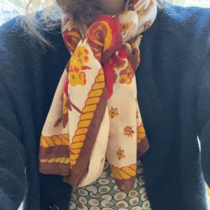 Vintage scarf i varma färger - Vintage halsduk med blommigt mönster i rött, gult och brunt på en vit bakgrund - fin kant i brunt och gult som ramar in mönstret snyggt.