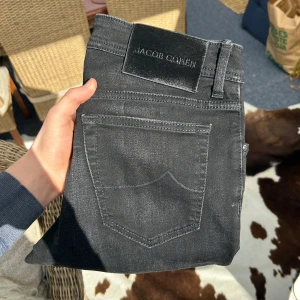 Svarta jeans från Jacob Cohen - Snygga svarta jeans från Jacob Cohen med klassisk femficksdesign. De har en rak passform och är tillverkade i ett mjukt och bekvämt material. Perfekta för en stilren look.