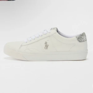 Vita sneakers från Polo Ralph Lauren - Snygga vita sneakers från Polo Ralph Lauren med glittriga silverdetaljer på hälen och plösen. Skorna har vit snörning och logga på sidan. Beställde dom men dom va för små när jag använde dom så är bara använda en gång. Man kan se att dom är använda under skorn samt lite inuti ena skorn på hälen men annars som nya. Passar storlek 39-40. Lådan följer med vid köp!💕
