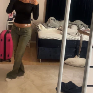 Gröna bootcut jeans - Snygga gröna bootcut jeans med låg midja. Perfekta för en avslappnad stil. De har en klassisk design med knappar och dragkedja framtill. Dessa är endast använda 2 gånger då jag tycker att de sitter lite för stort på mig. Nypris 700kr men då de är på rea på dessa just nu säljer ja de betydligt mycket billigare än vad jag köpte de för. 