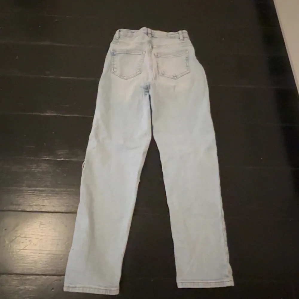 Ett par utsvängda jeans med hål i knäna. Storlek 146🤍. Farkut & Housut.