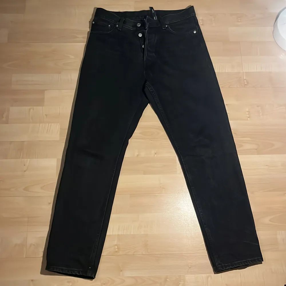 Säljer ett par svarta jeans från Weekday i modellen Barrel Relaxed Tapered. De har en avslappnad passform med avsmalnande ben och är tillverkade i ett bekvämt material. Perfekta för en stilren look.. Farkut & Housut.