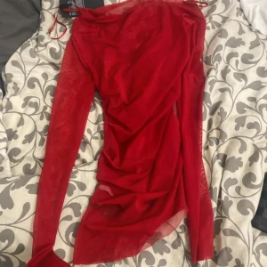 Röd transparent långärmad topp från Weekday - Säljer en röd transparent långärmad topp från Weekday. Toppen har en draperad design och är perfekt för att lägga till en touch av färg och stil till din outfit. Tillverkad i ett lätt och luftigt material.