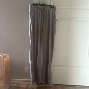 Grå mjukisbyxor  - Säljer ett par grå mjukisbyxor från Green Studio. Byxorna har en elastisk midja med snörning och praktiska fickor baktill. Perfekta för en avslappnad stil. Aldrig använda med lapp kvar.