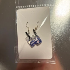 Blå örhängen med blommönster - Charmiga örhängen formade som små dryckesglas med blått blommönster och sugrör. Perfekta för att ge en lekfull touch till din stil. (Billigt material) 