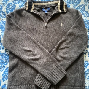 Grå stickad tröja från Polo Ralph Lauren - Säljer en grå polo ralph lauren half zip, skick 8,5/10, sparsamt använd inga defekter. Säljes på grund av att jag växt ur den. Sitter som xs. Hör av dig vid frågor pris kan diskuteras