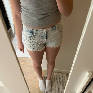Ljusa jeansshorts med nitar - Jättefina ljusblå jeansshorts med nitar på vänster sida, de har kommit till användning ett flertal gånger men är fortfarande i väldigt fint skick, enda lilla defekt är en pytteliten brun fläck på baksidan annars är de nästan som nya🥰🥰