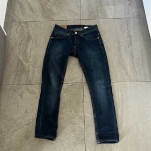 Mörkblå jeans från Dondup - Snygga mörkblå jeans från Dondup med klassisk femficksdesign och kontrastsömmar. Jeansen har en rak passform och är perfekta för en avslappnad stil. De har en knappgylf och är tillverkade i ett slitstarkt denimtyg. Dm för frågor men dom är i ny skick. 😇