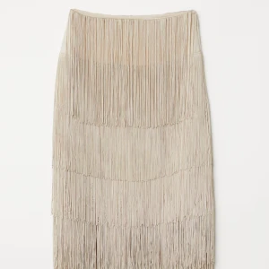 Beige kjol med fransar - Snygg beige kjol med långa fransar som ger en härlig rörelse. Perfekt för att sticka ut med en unik stil. Kjolen har en rak passform och är i en neutral färg som passar till mycket.