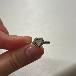 Promisering från Pandora!!! -  Silverring från Pandora med en gnistrande hjärtformad sten i mitten. Använd en del, men saknar inga stenar! nypris 899kr!!