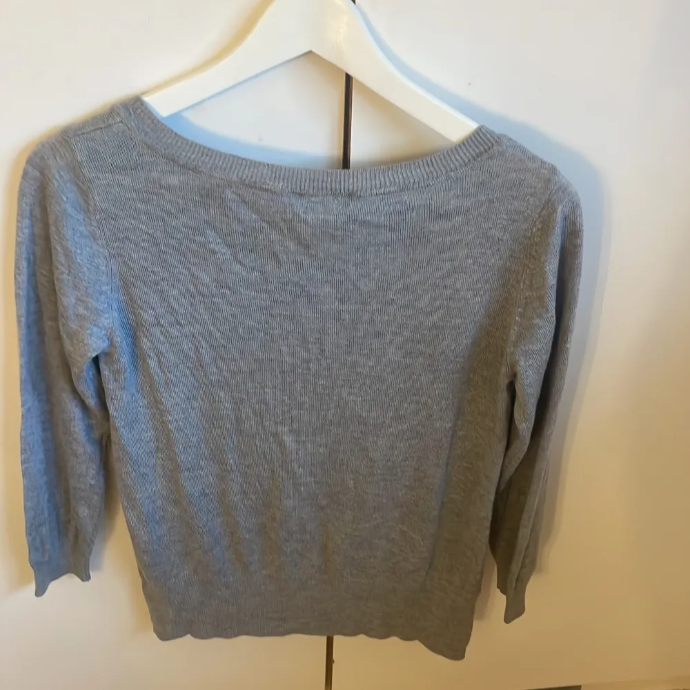 Säljer en stilren grå tröja från H&M. Tröjan har en rund halsringning och trekvartsärmar, perfekt för en avslappnad look. Tillverkad i ett mjukt material som känns skönt mot huden.. Puserot.