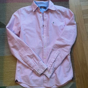 Morris skjorta - Säljer en riktigt snygg skjorta från morris. Skjortan är rosa randig, perfekt till sommarn. Bra skick, enda är att den har en liten fläck som säkert går bort (se bild 4), man tänkter inte på den så mkt. Hör av er vid frågor. /Tom🕺