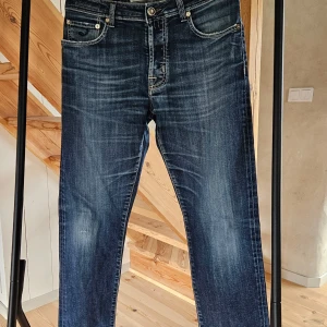 Blå jeans från Jacob Cohen - Snygga blå jeans från Jacob Cohen med klassisk femficksdesign och kontrastsömmar. Jeansen har normal passform och är tillverkade av högkvalitativt denim med lätt tvättad look. Perfekta för dig som gillar stilrena och tidlösa jeans. Hör av er för fler bilder, på lappar