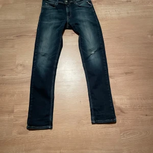 Replay Hyperflex jeans i mörkblå denim - Säljer ett par Replay Hyperflex jeans i mörkblå tvätt med lätt slitna detaljer. Klassisk femficksmodell med normal passform och raka ben. Stretchigt material för extra komfort. Perfekta till sköna outfits