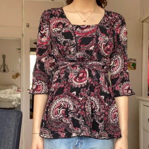 Mönstrad blus 💫 - En lång blus med fina mönster på. Storleken är 42 / L men jag tror att man kan köpa den oavsett vilken storlek man har nästan. Man kan ha den som en väldigt kort klänning om man vill det också 🥰 den har två snören på sidan som man kan knyta som man vill 🫶 tryck på köp nu :))