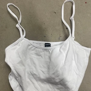 Vit linnetopp från SHEIN - Säljer en enkel och stilren vit linnetopp från SHEIN. Toppen har tunna axelband och är perfekt för varma dagar eller som lager under andra plagg. Passar dig som gillar minimalistisk stil.