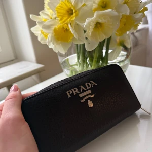 Plånbok - Snygg svart plånbok med silverfärgad dragkedja och logga framtill. Plånboken har flera fack för kort och sedlar, perfekt för att hålla ordning på dina värdesaker. Klassisk och stilren design. Finns i Linköping annars kan jag posta och då får man såklart postbevis samt spår nummer. 500kr ☺️