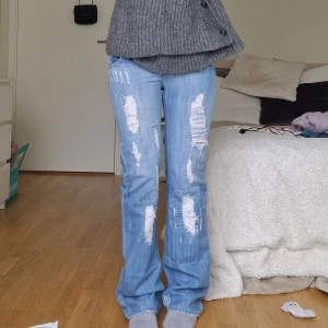 Ljusblå slitna bootcut jeans - Säljer ett par ljusblå lågmidjade jeans med bootcut passform och kraftiga slitningar framtill och baktill då de tyvärr var små. Perfekta för en avslappnad och trendig look. Skriv för mer info! 💓