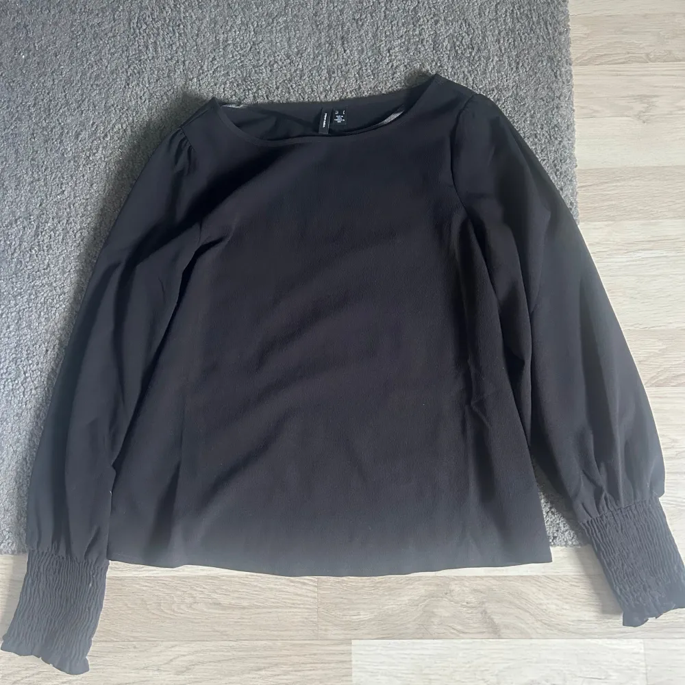 Säljer en svart blus från Vero Moda med långa ärmar och smockade muddar vid ärmsluten. Blusen har en rak passform. Säljer för jag ej använder.. Puserot.
