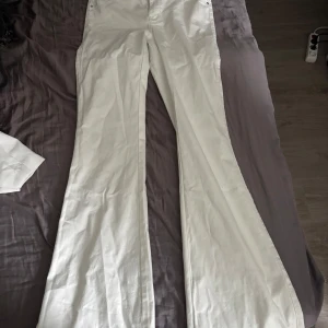 Vita bootcut jeans madlady-tall - Säljer ett par vita jeansbyxor med bootcut-passform. Byxorna har klassisk och stängs med dragkedja och knapp. Perfekta för dig som vill ha en stilren och fräsch look extra långa.